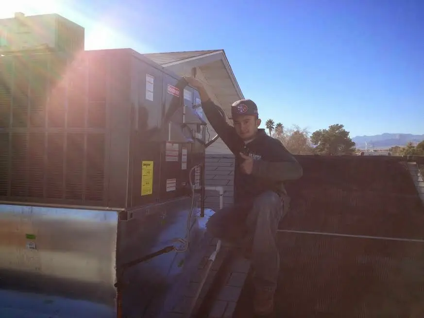 HVAC technician performing Heat Pump Repair on a rooftop unit in Thornbury