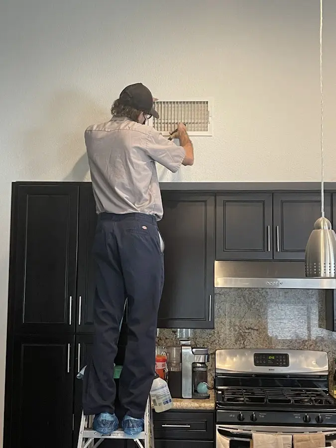 Technician inspecting an air vent during HVAC service in Thornbury